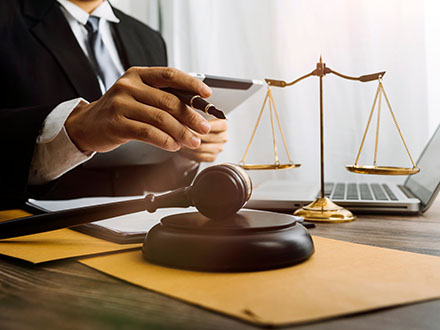 Gavel and legal documents beside a laptop